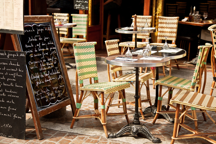 set table on a Paris sidewalk next to menu board - why do i get a gluten reaction with american vs european wheat overseas