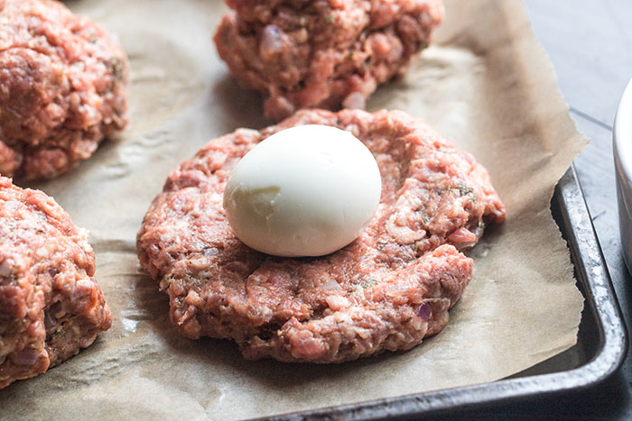flattened rounds of meat with an egg on top for scotch eggs mini meatloaf recipe