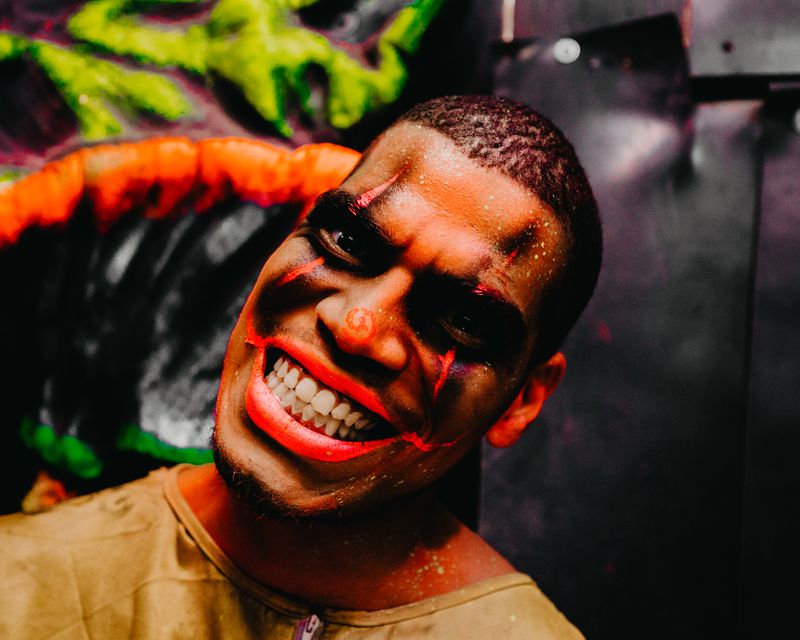 Up close photo of a man smiling with creepy halloween face paint. 