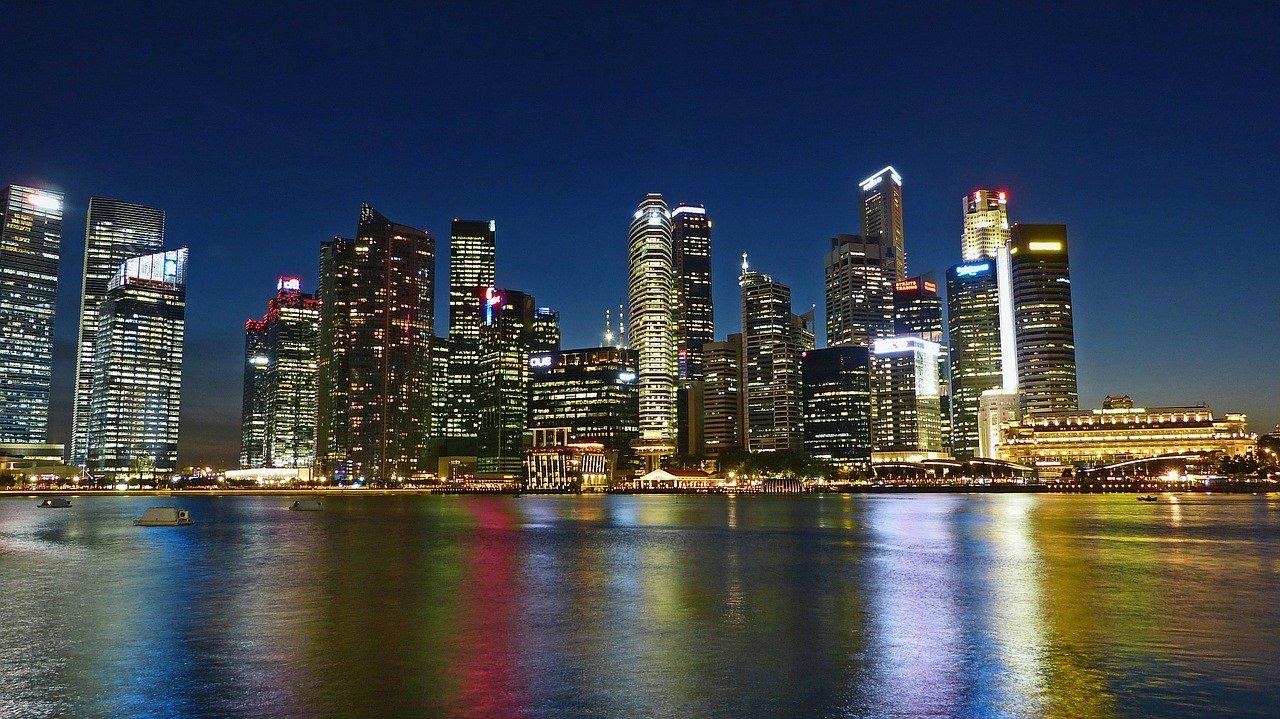 View of lit city at night by the beach