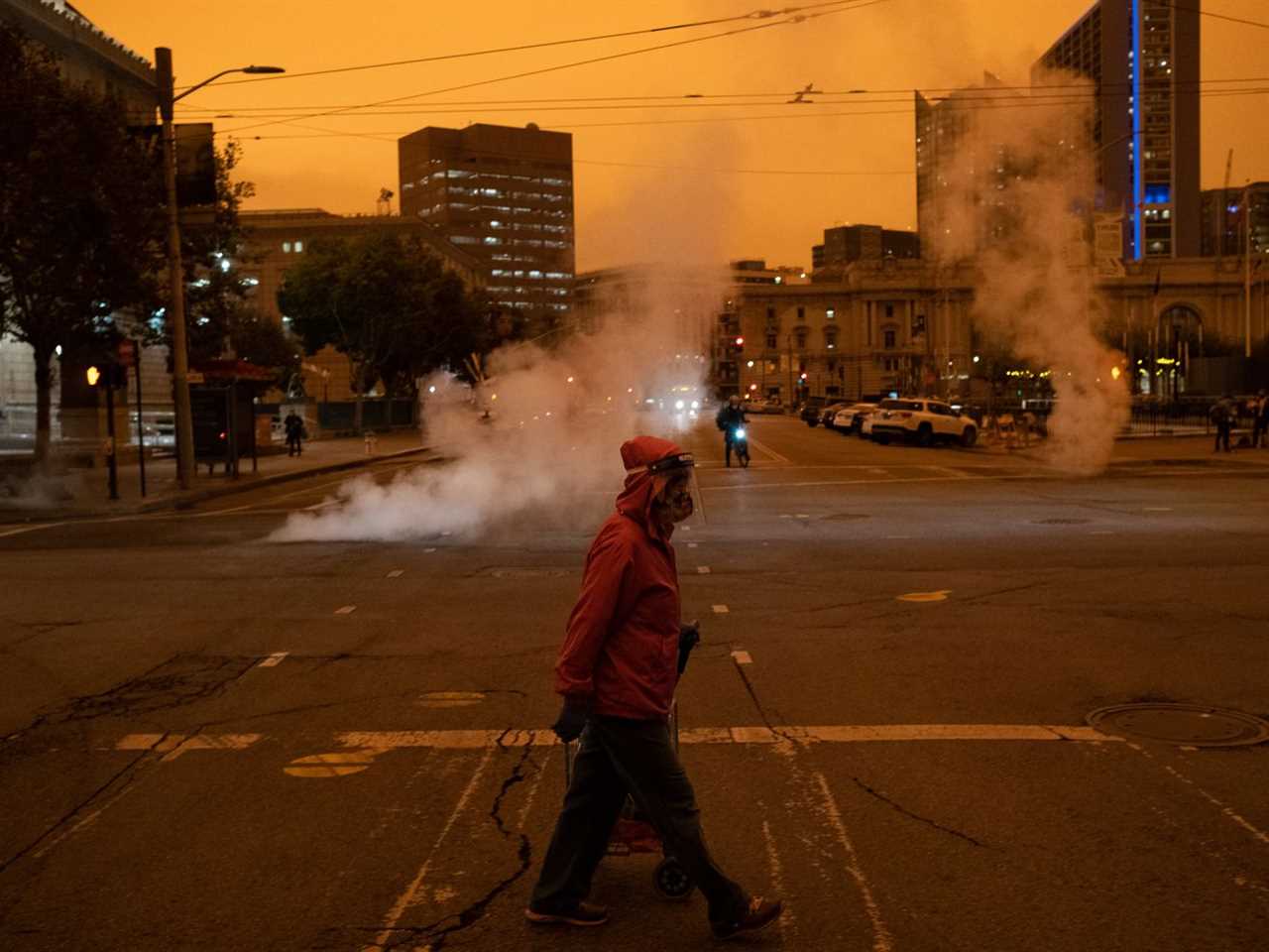 A pedestrian in San Francisco walking under a thick orangey-yellow sky