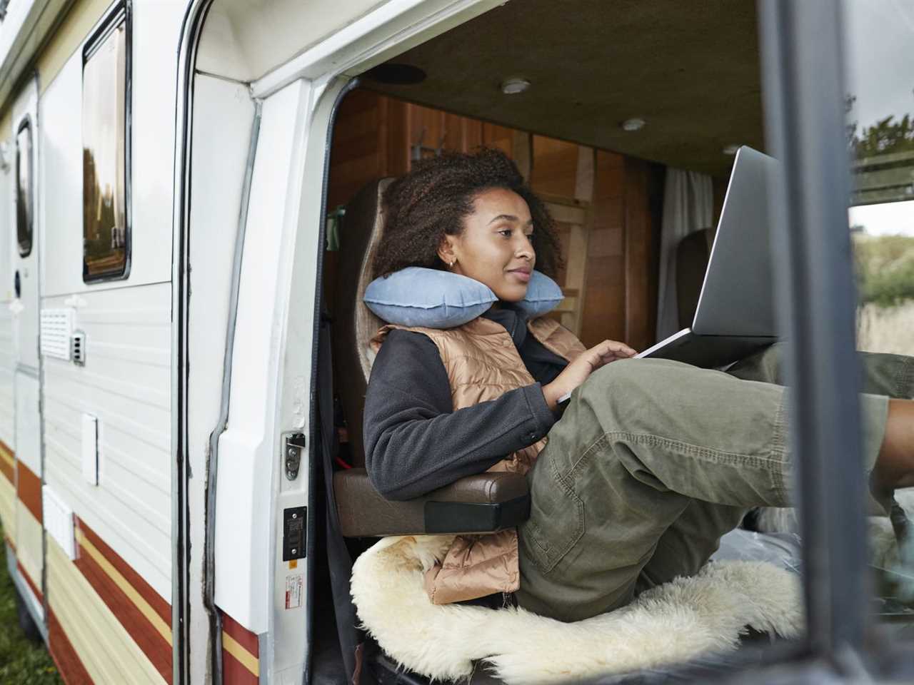 Woman working in an RV on her laptop.