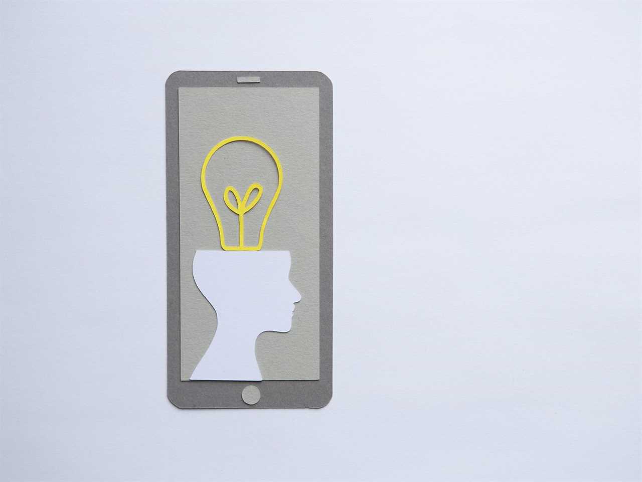 Paper cut-out of a phone, featuring a silhouette of a human head attached to a yellow lightbulb.