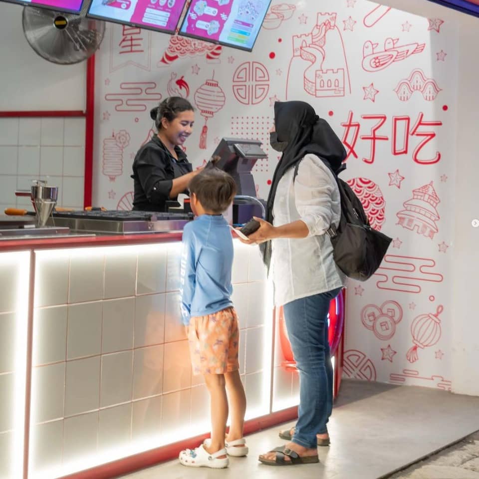 woman and kid ordering food at atlas beach club in bali