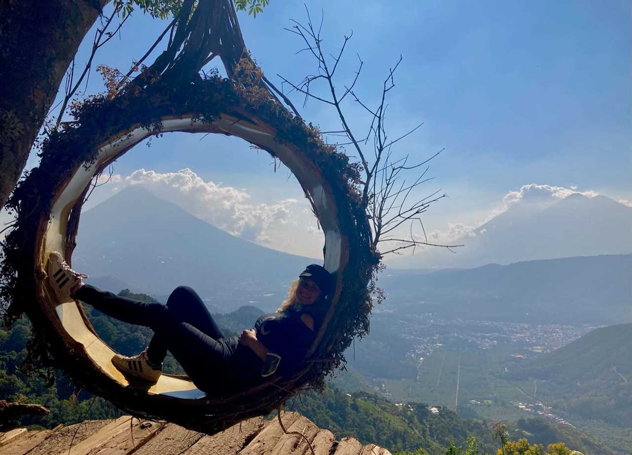 woman lying inside a wood circle on top of a mountain at altamira guatemala