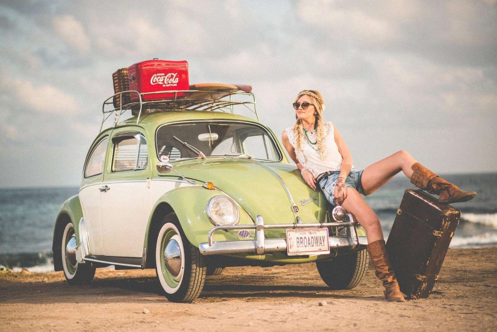 woman resting on a car with luggage