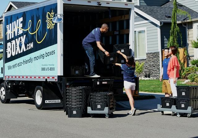 A man in a truck helping unload it. 