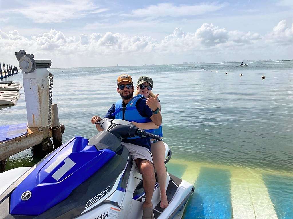 man and woman riding a waverunner in cancun