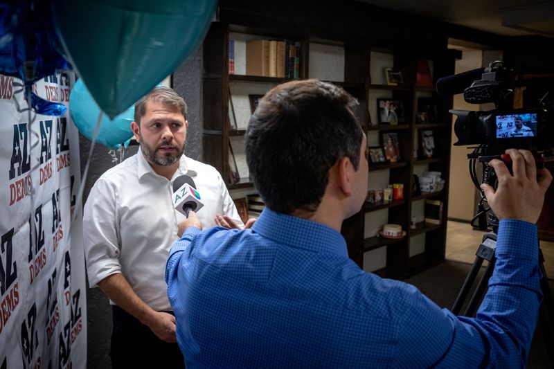 A videographer holds a microphone out to Gallego inside a studio.