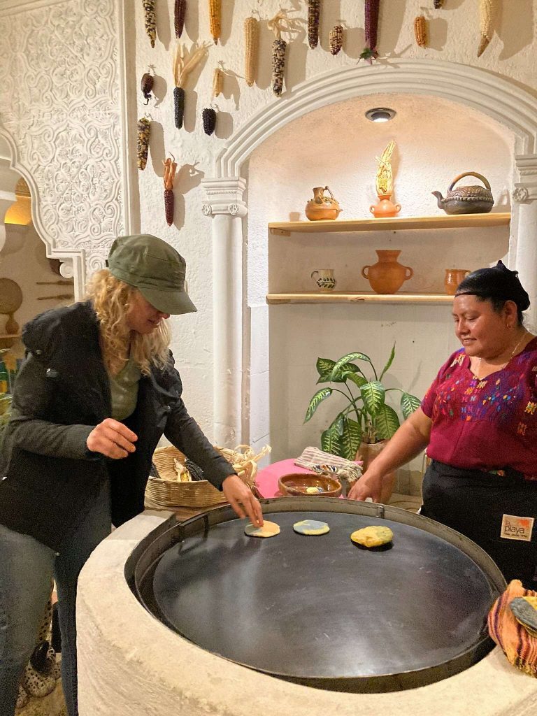 two womans making tortillas on a comal at el comalote restaurant antigua guatemala