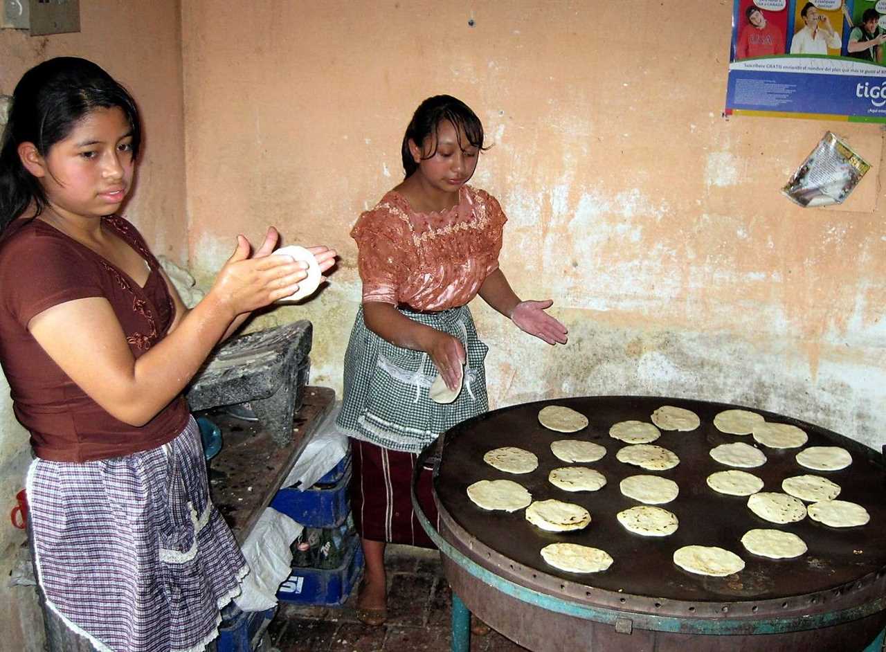 two womans making tortilla in a comedores in guatemala