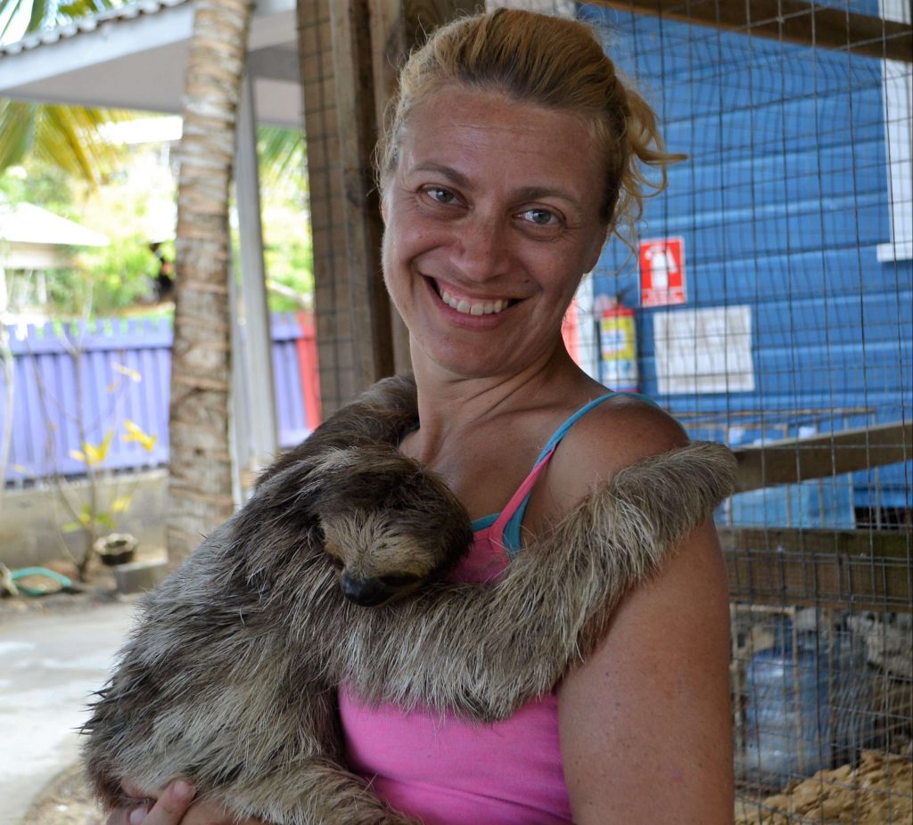 woman with a sloth in a sanctuary in roatan honduras