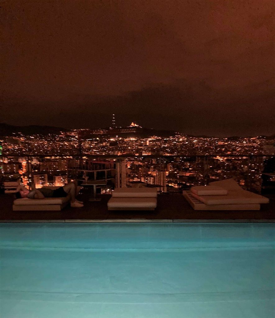 barcelona view at night from a pool at the renaissance fira hotel