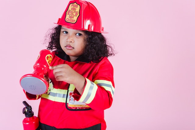 A girl wearing a firefighter costume at KidZania—a must when visiting Dubai with kids