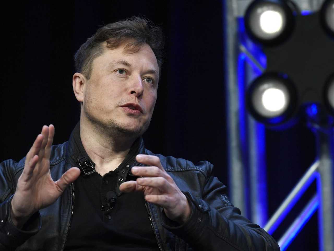 Musk speaking and gesturing with his hands.