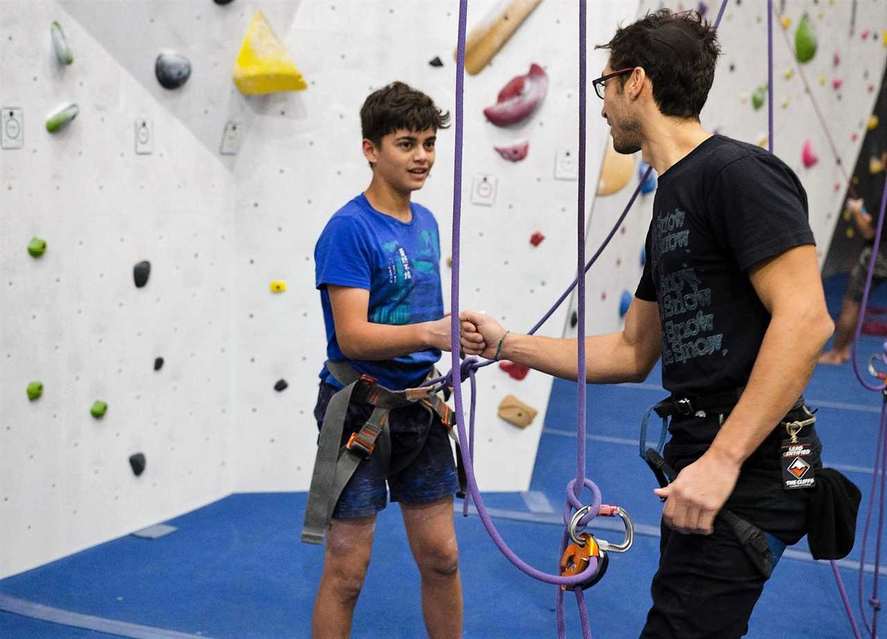 two guys shaking hands in a indoor climbing gym