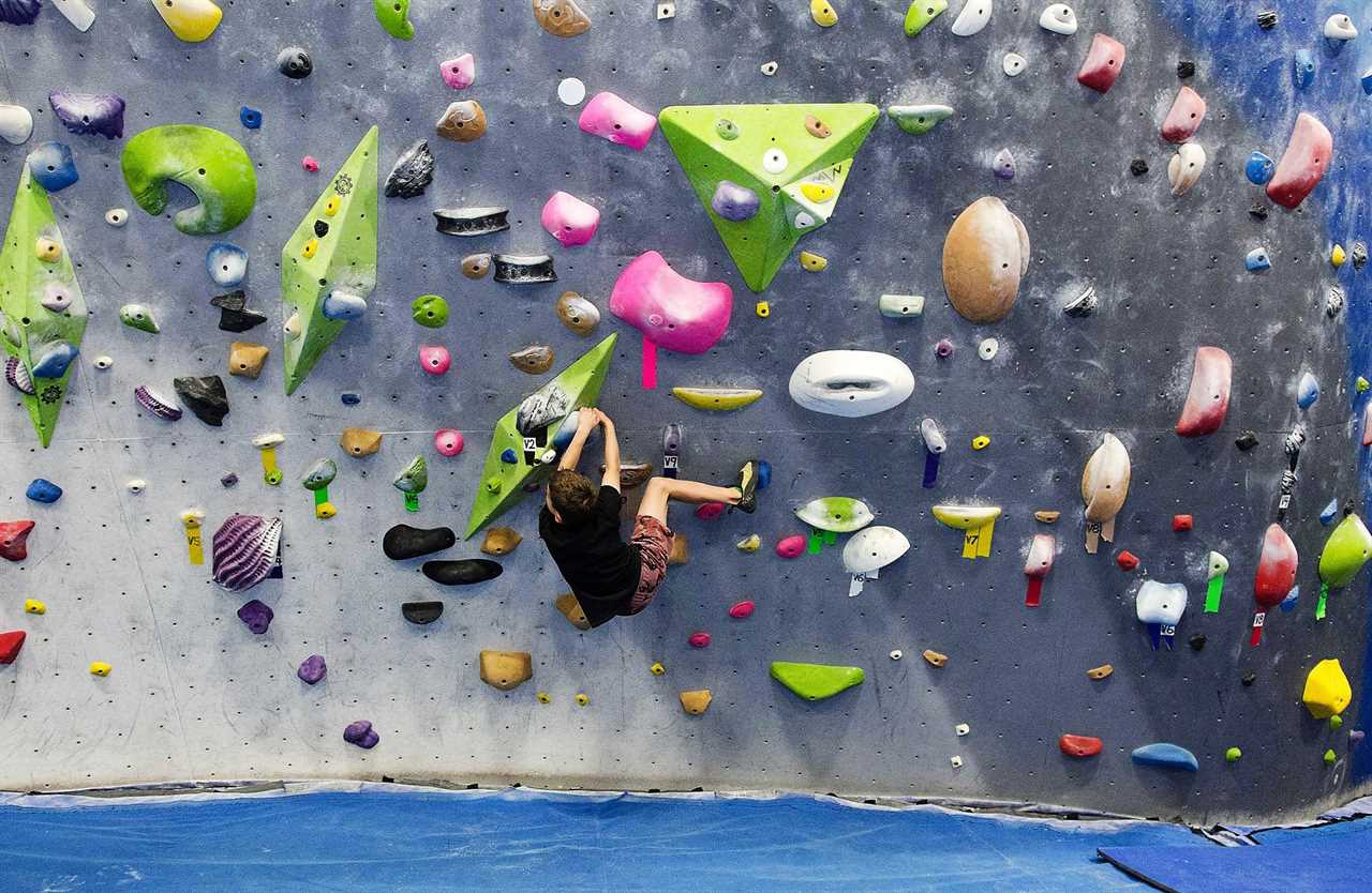 kid doing bouldering in a indoor climbing gym