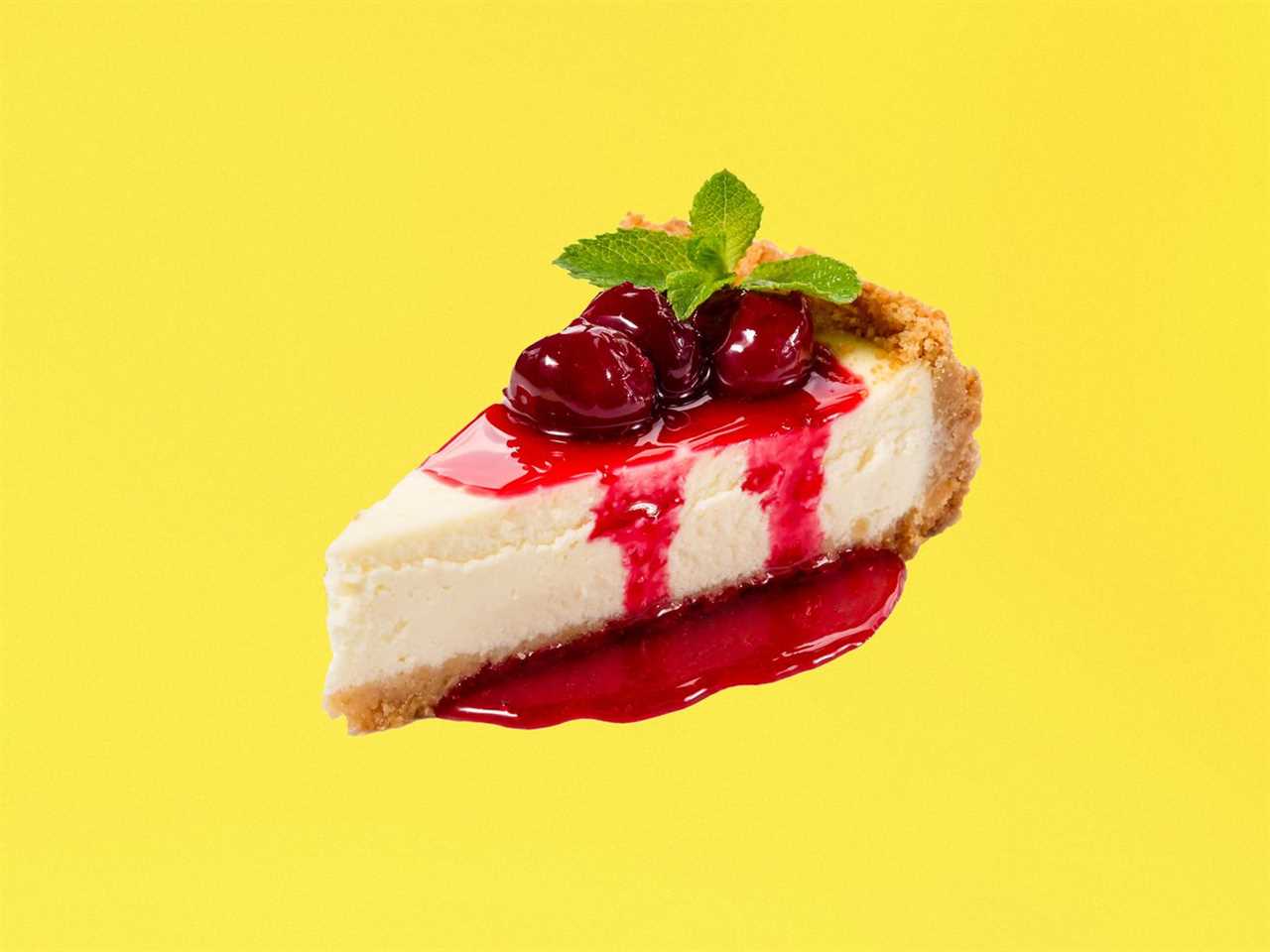 A slice of cheesecake with cherries and red sauce and a mint sprig, floating on a neutral background.