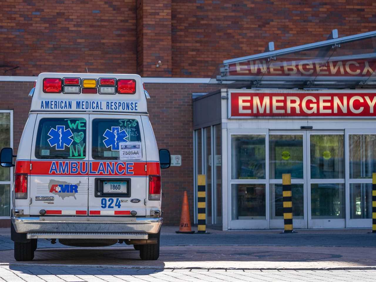 A photo of the exterior of an emergency room and an ambulance. 