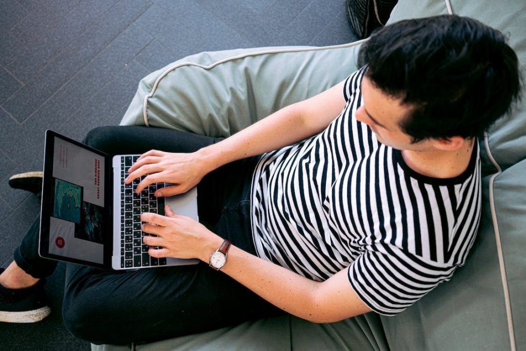 guy using a laptop while sitting on a couch