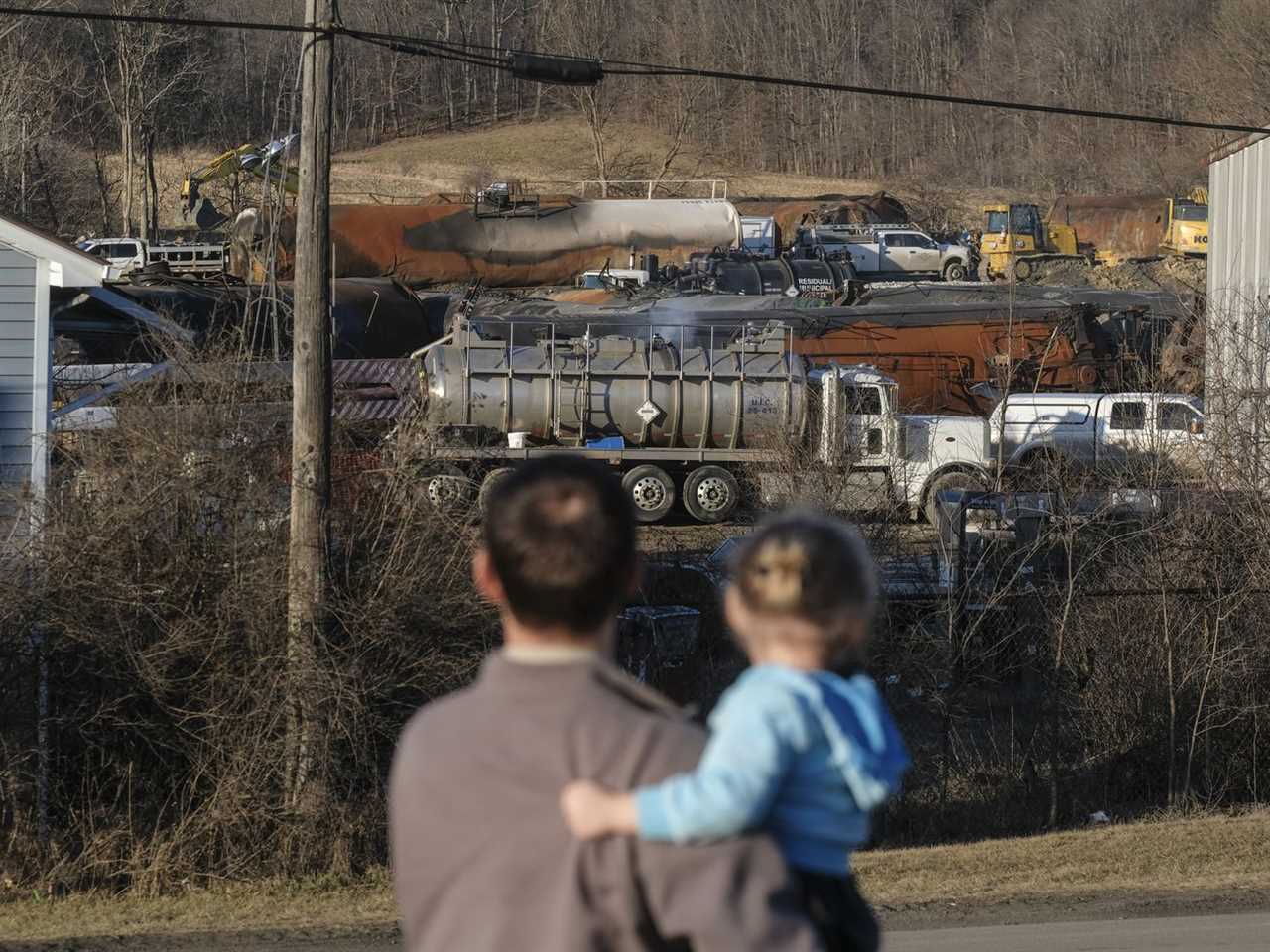 A family from Pennsylvania inspects the wreckage of the Norfolk Southern train derailment in East Palestine, Ohio, on February 19, 2023.