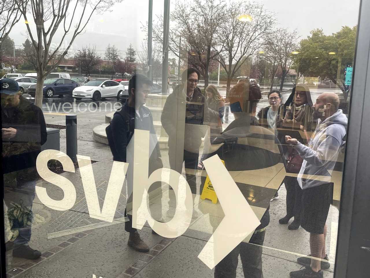 People standing outside Silicon Valley Bank, which is closed, in Santa Clara, California, on March 10, 2023.