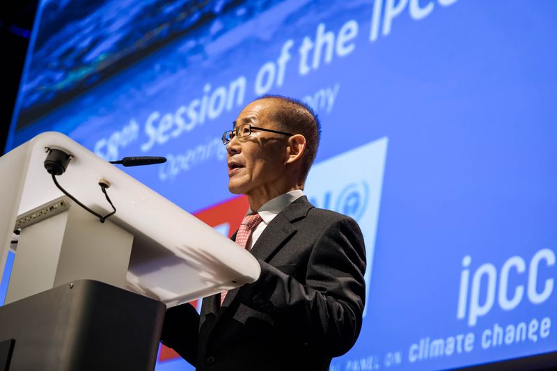 IPCC chair Hoesung Lee speaks from a lectern, with a blue screen behind him showing the IPCC logo.