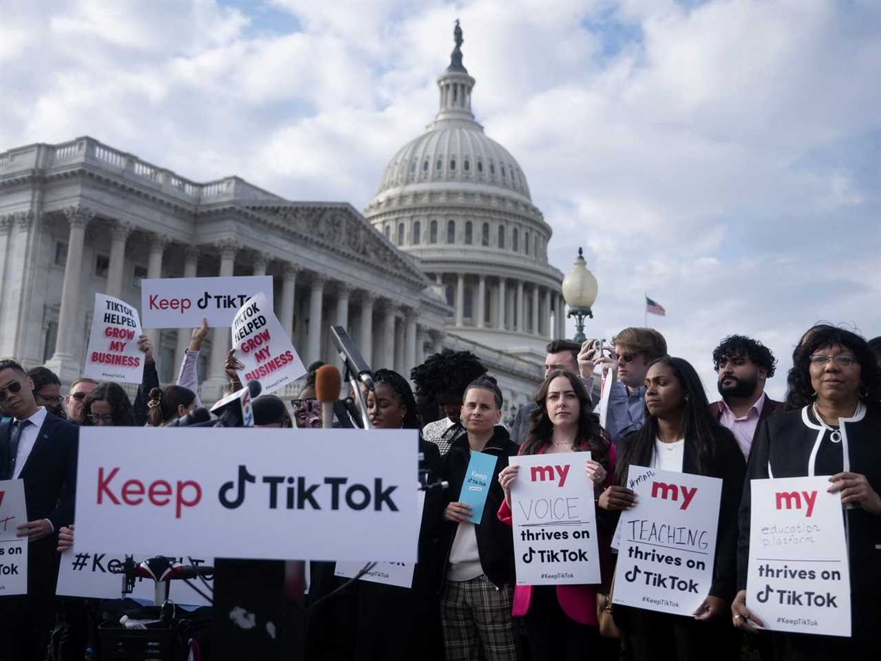 A group of protesters gather in front of the US Capitol building, holding signs that support TikTok.