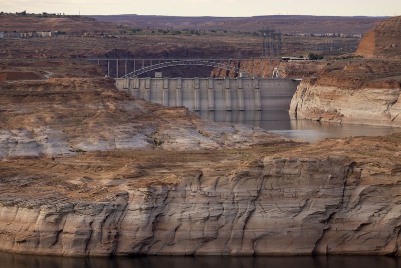 Glen Canyon Dam and the light colored “bathtub ring” that was left on the landscape as water levels receded are seen at Lake Powell on September 1, 2022 near Page, Arizona.