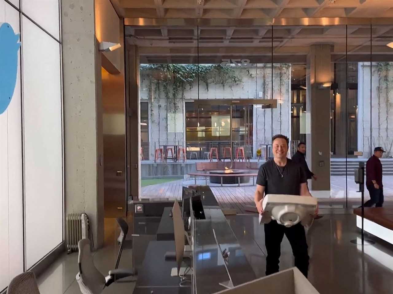 Elon Musk in the Twitter headquarters holding a sink.