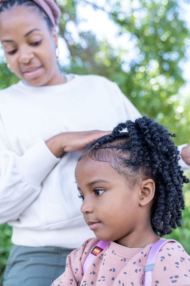 Stephanie McWoods touches her daughter’s head.