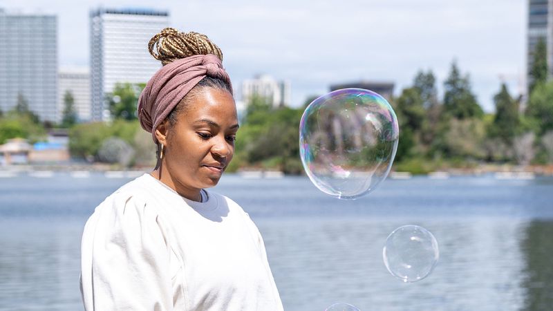 Stephanie McWoods blowing bubbles in front of Lake Merritt in Oakland, California.&nbsp;