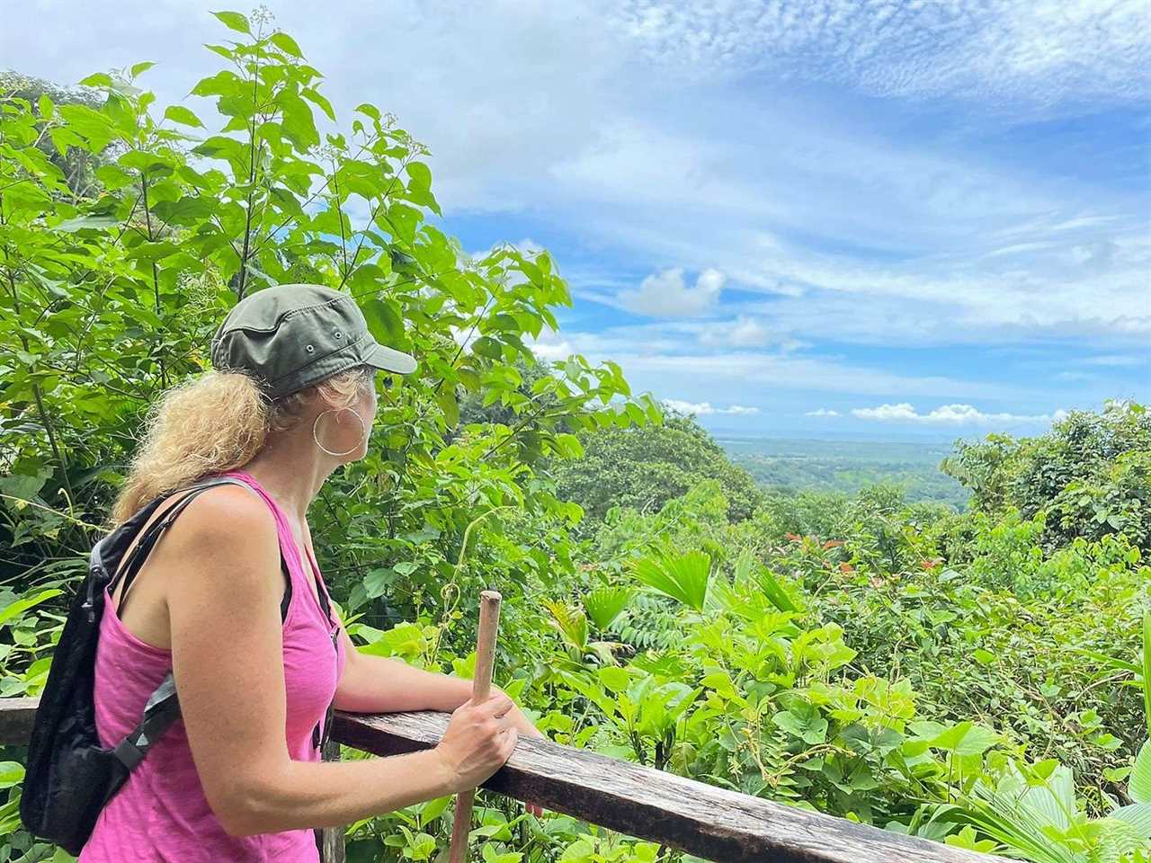 woman looking to the forest at rainmaker conservation park in costa rica