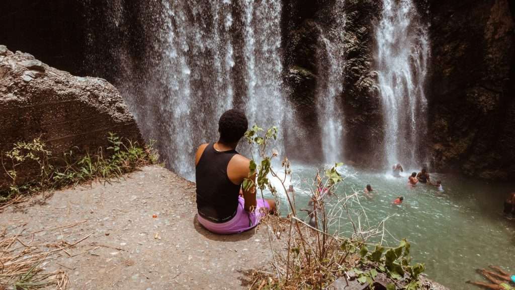 Man sitting in front of a fall in Jamaica