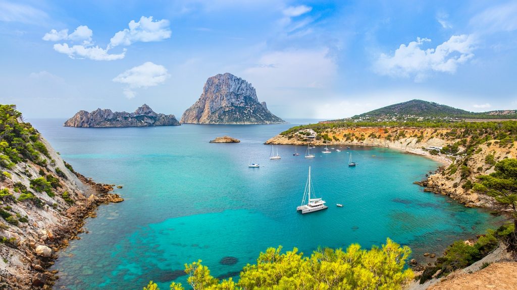 some yatch on the water near rock formations in Cala d'Hort, Ibiza