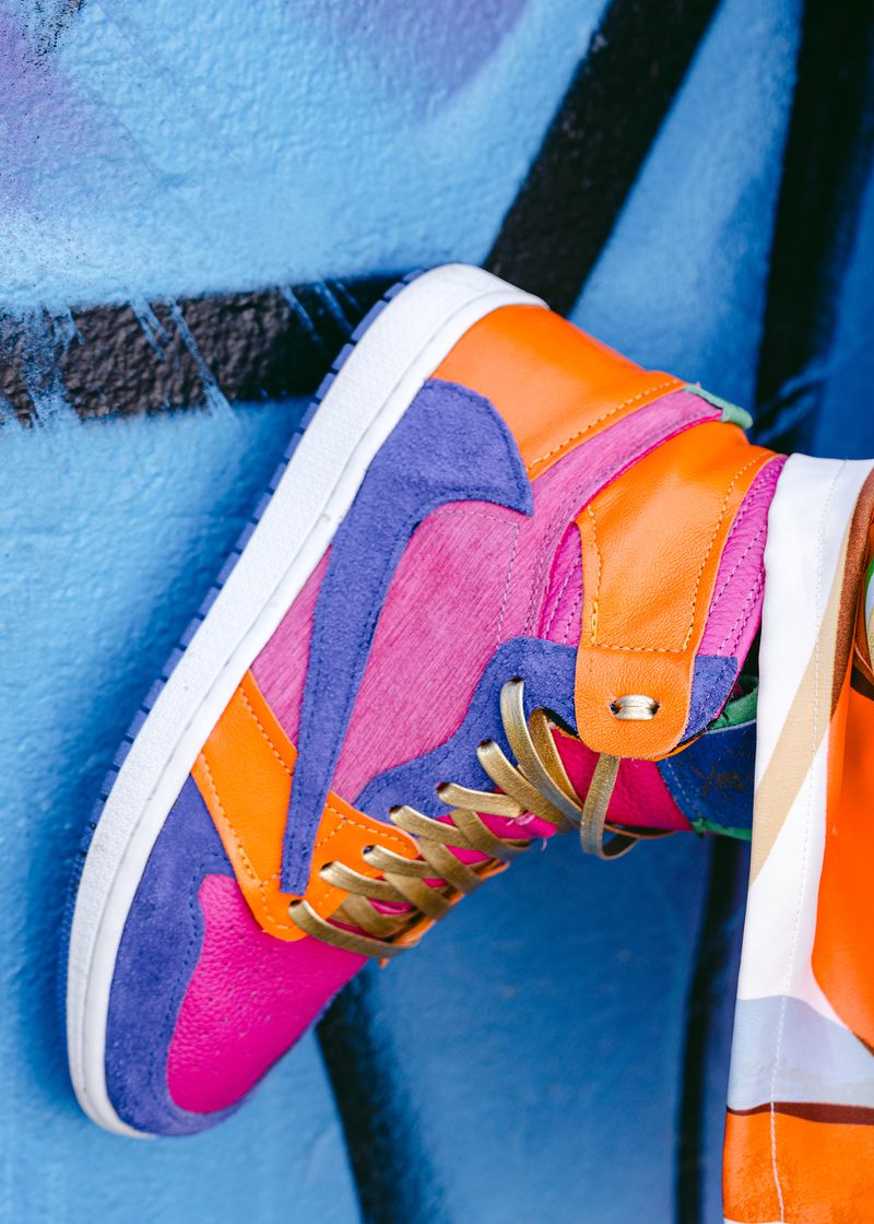 A high-top sneaker in purple, pink, and orange color blocks.