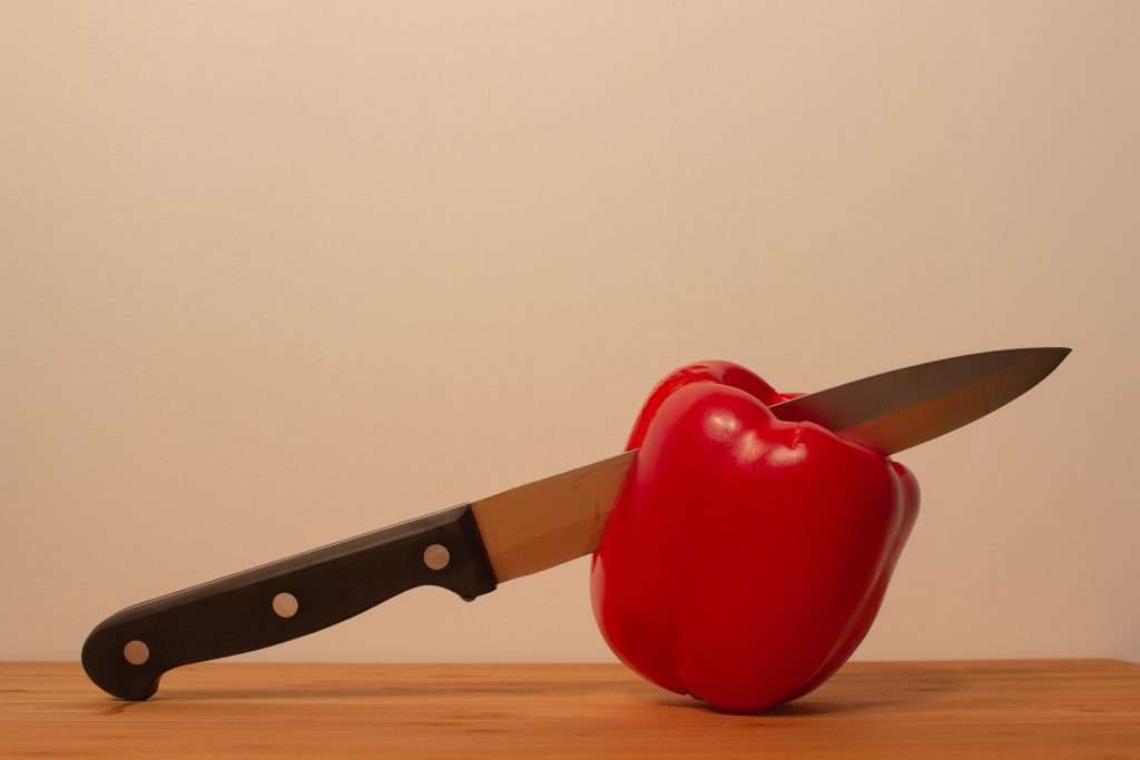 Rare knife cutting a red pepper