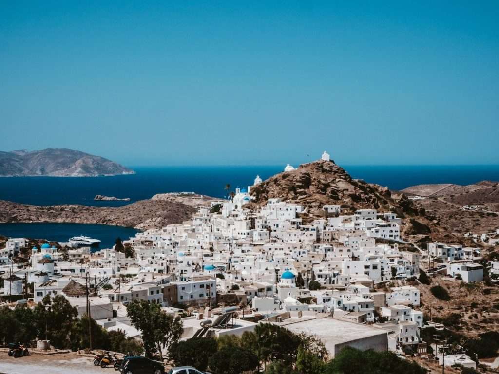 white houses on a hill with the sea in the background in Ios island, Greece