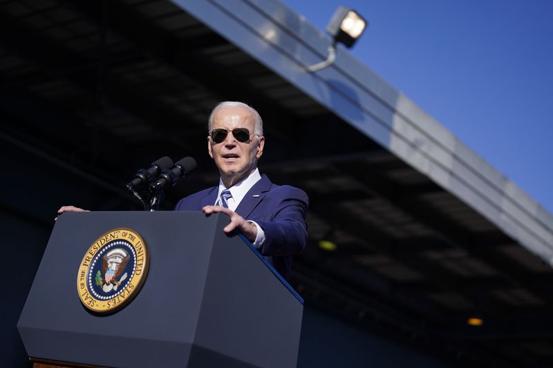 President Biden stands outdoors at a lectern.