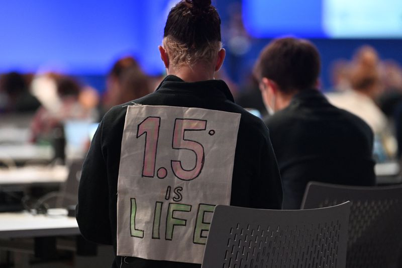 A delegate bearing a sign on his back that reads “1.5°C is life” attends the People’s Plenary during the COP26 UN Climate Change Conference in Glasgow on November 12, 2021.