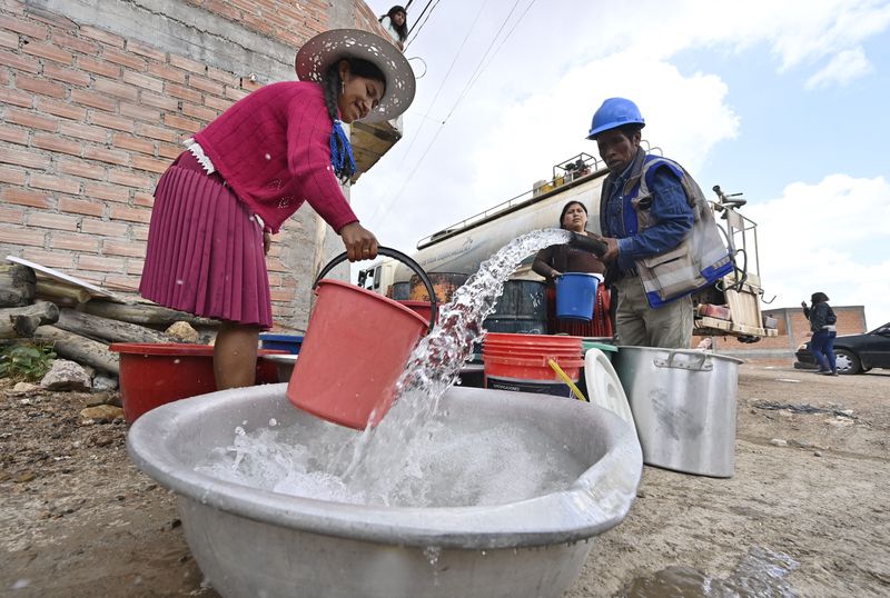 Residents of the hillside neighbourhoods of Potosi, Bolivia receive water from a tanker truck that supplies them once a week, as the region is being affected by a severe drought, on November 7, 2023.