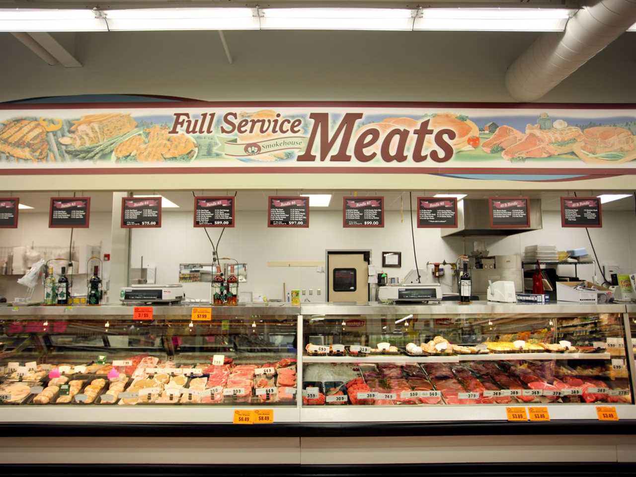 A meat counter at a grocery store with the sign “full service meats.”