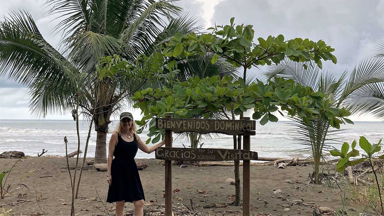 woman next to a welcome sign in dominical costa rica