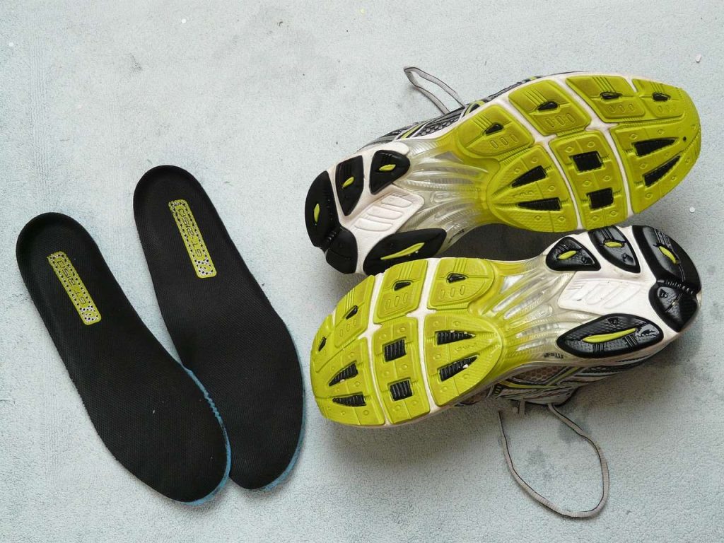 a pair of upside down shoes next to a pair of insoles