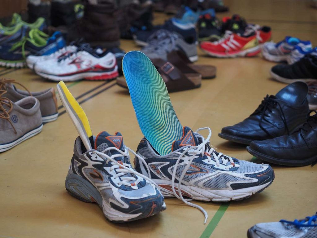 shoes with insole out on top of a wooden floor