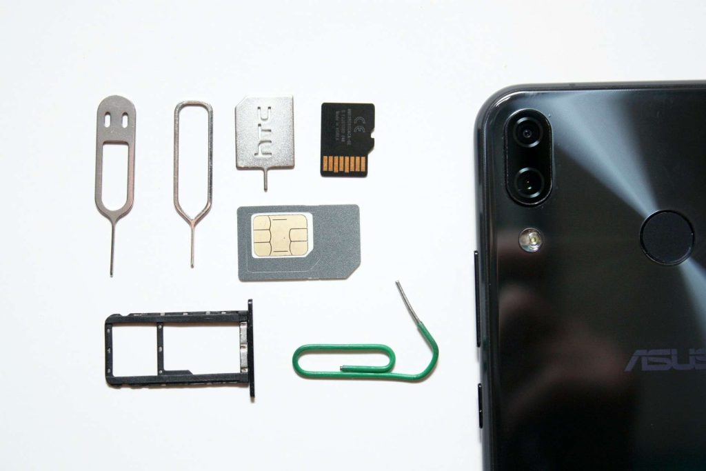 phone next to a sim card and different tools