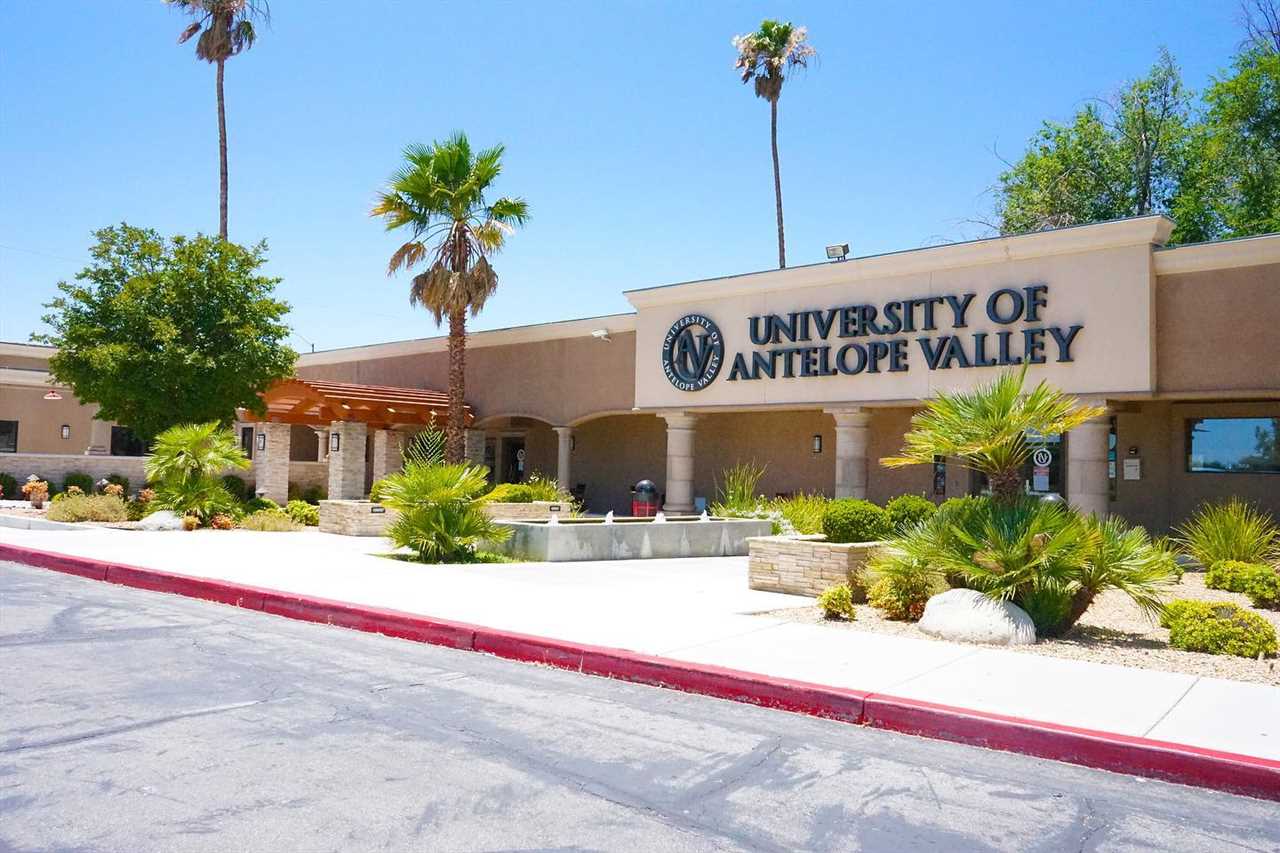 The exterior of a building with the University of Antelope Valley in large letters above the entrance. Small bushes and trees dot the nearby landscape.