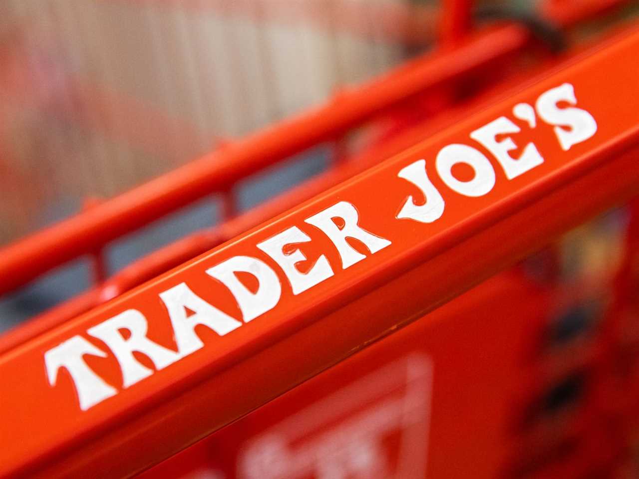 A Trader Joe’s logo on a shopping cart handle in orange and white.