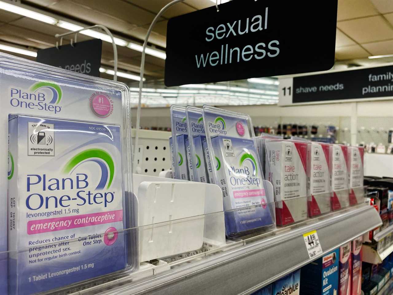 Packages of Plan B sit on a shelf in a store aisle labeled “sexual wellness.”