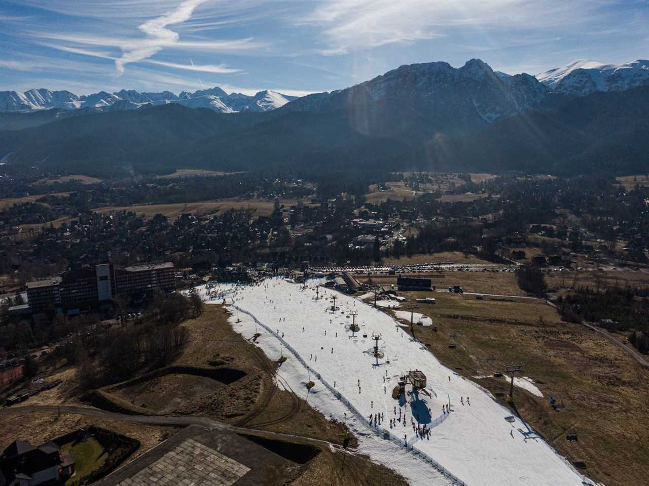 An aerial view of a ski slope operating with a small amount of snow during an unusually high-temperature day in Zakopane, Poland, on February 16, 2024.